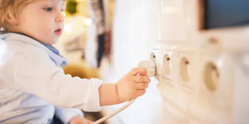 Toddler plugging in a cord