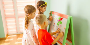 Children practicing math on an easel