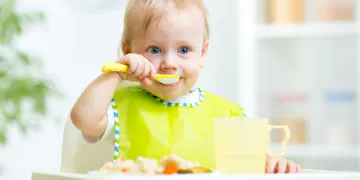 Toddler eating with spoon