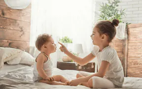 Siblings Playing Together on Bed