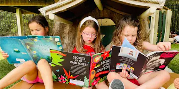 Three girls enjoying their favorite books with the help of our reading nook ideas!