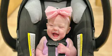 This happy baby is proudly displaying our topic: best infant car seats!