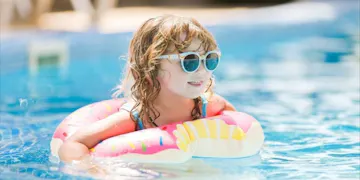 This child is enjoying the pool with the help of her parents' water safety tips.