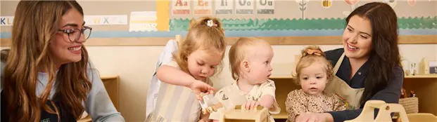 Teacher guiding children through a hands-on activity in a nurturing preschool program.