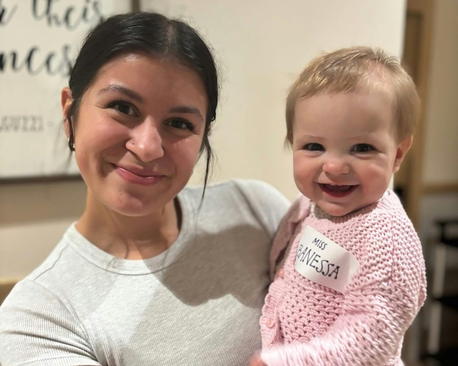 This Little Sunshine's Playhouse teacher is holding an adorable baby.
